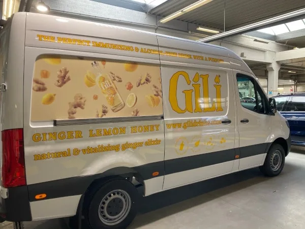 Witte bestelwagen met belettering voor een drankmerk