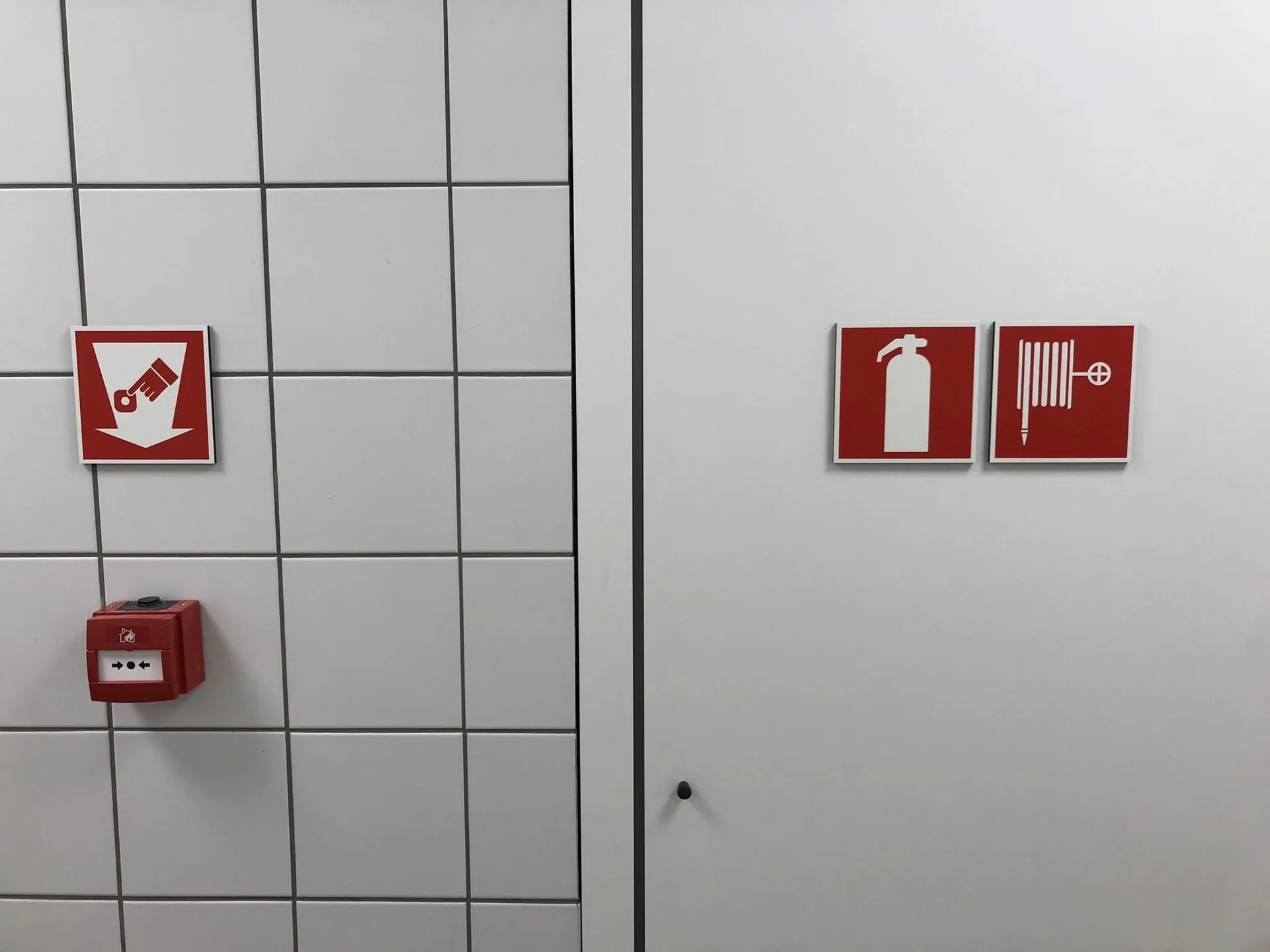 Rode brandveiligheidsborden op een tegelwand